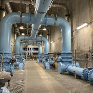 Large pipes painted light blue inside of a water treatment plant