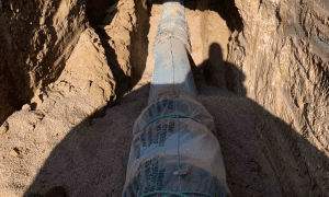 Exposed pipeline being installed in trench