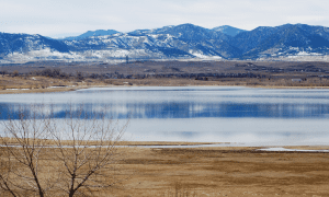 Large reservoir in front of snow covered foothills