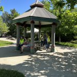 People around a picnic table shelter in a park